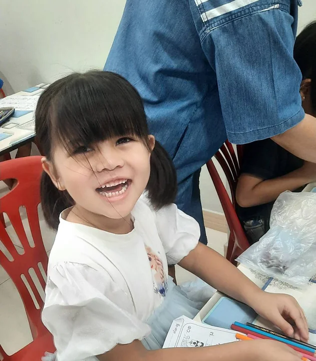 น้องยิ้มสดใสระหว่างทำใบงานภาษาไทย